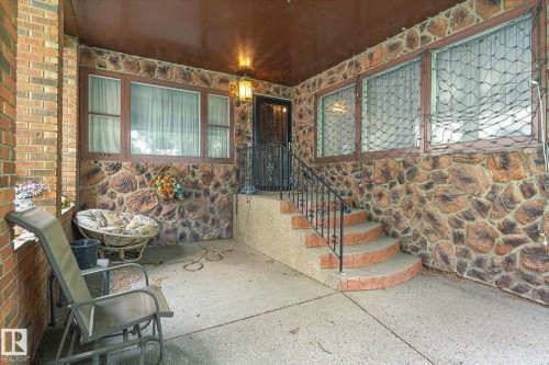 Stone veneer exterior with a concrete patio - 9747 67 Avenue, Edmonton, AB 