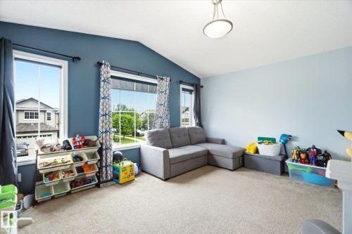 Carpeted room featuring a vaulted ceiling and a contemporary semi-flush mount light fixture - 1744 61 Street, Edmonton, AB 