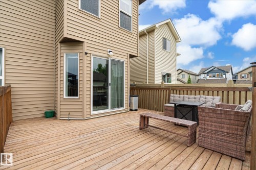 Spacious wood-plank deck featuring a privacy fence, sliding glass door access, and a bay window - 1744 61 Street, Edmonton, AB 
