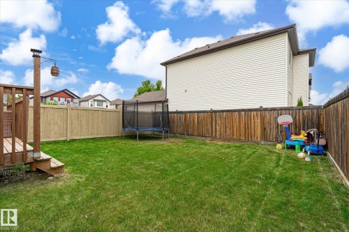 Expansive backyard featuring a manicured lawn, a multi-level wooden deck, and full perimeter fencing - 1744 61 Street, Edmonton, AB 