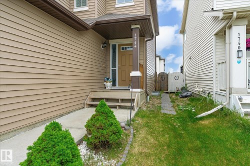 Front entrance featuring a covered porch, wood-look siding, and a concrete walkway - 1744 61 Street, Edmonton, AB 
