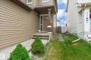 Front entrance featuring a covered porch, wood-look siding, and a concrete walkway - 1744 61 Street, Edmonton, AB 