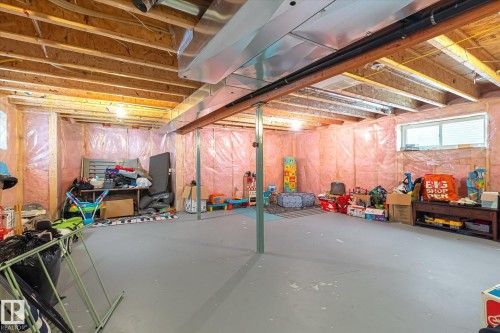 Unfinished basement featuring exposed wood joists, structural support beams, and a concrete floor - 1744 61 Street, Edmonton, AB 