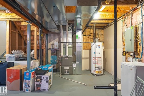Utility area featuring a water heater, furnace, and exposed ductwork - 1744 61 Street, Edmonton, AB 
