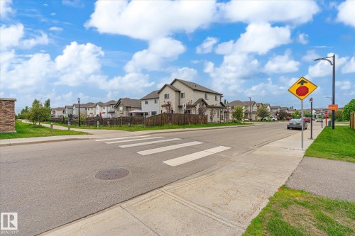 Residential street with concrete sidewalks, pedestrian crosswalks, street lighting, and manicured grass verges - 1744 61 Street, Edmonton, AB 