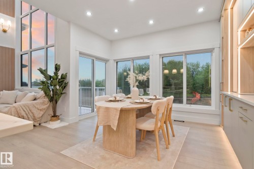 Bright dining area featuring wood-finish flooring, recessed lighting, and expansive windows - 3305 Chickadee Drive, Edmonton, AB 