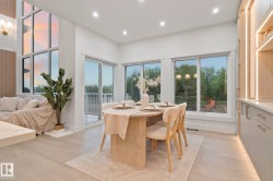 Bright dining area featuring wood-finish flooring, recessed lighting, and expansive windows - 