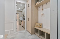 Custom built-in mudroom cabinetry with shelving and seating, complemented by hexagon pattern floor tiles - 
