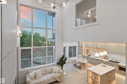 Two-story living area featuring a prominent full-height window, a coffered ceiling, and wood-finish flooring - 