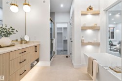 Contemporary bathroom featuring a freestanding soaking tub and a wood-finish vanity with a light-toned countertop - 