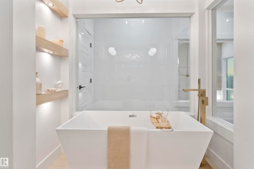 Freestanding soaking tub with a floor-mounted gold-tone faucet - 3305 Chickadee Drive, Edmonton, AB 