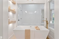 Freestanding soaking tub with a floor-mounted gold-tone faucet - 