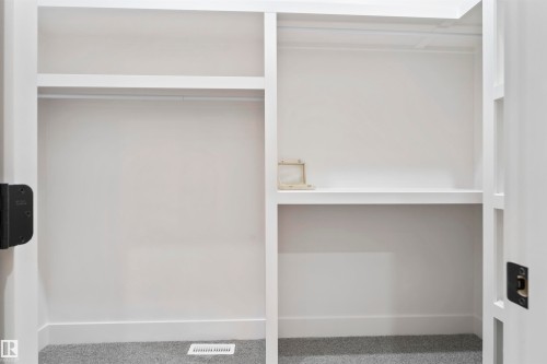 Custom closet system featuring white shelving and hanging rods - 3305 Chickadee Drive, Edmonton, AB 