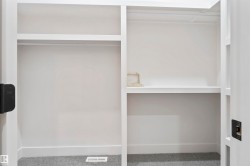 Custom closet system featuring white shelving and hanging rods - 