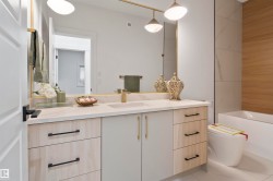 Floating vanity with a light-toned countertop, integrated sink, and gold-finish faucet - 