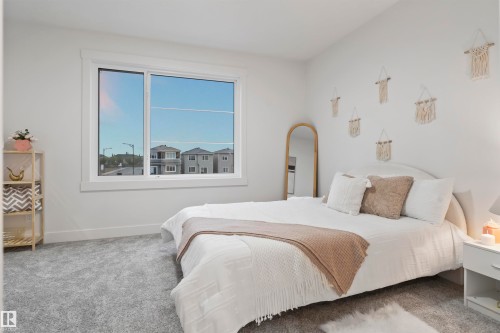 Large window with white trim, light gray wall-to-wall carpeting, and a neutral color palette throughout - 3305 Chickadee Drive, Edmonton, AB 