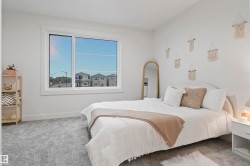 Large window with white trim, light gray wall-to-wall carpeting, and a neutral color palette throughout - 
