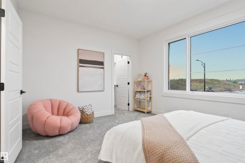 Bright room featuring a large window, plush gray carpeting, and white interior doors with contemporary black hardware - 3305 Chickadee Drive, Edmonton, AB 