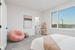 Bright room featuring a large window, plush gray carpeting, and white interior doors with contemporary black hardware - 