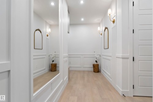 Hallway featuring light wood-finish flooring, recessed lighting, and decorative wall paneling - 3305 Chickadee Drive, Edmonton, AB 