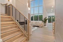 Hardwood staircase with integrated step lighting and black metal balusters - 