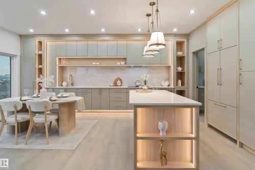 Contemporary kitchen featuring recessed lighting, a central island with integrated shelving, under-cabinet lighting, a built-in refrigerator, and light wood-finish flooring - 3305 Chickadee Drive, Edmonton, AB 