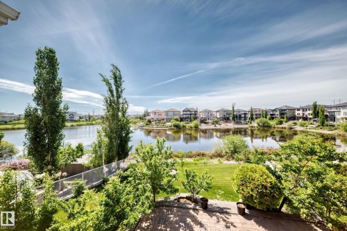 Spacious backyard with a paved patio, manicured lawn, and mature landscaping - 352 Ozerna Road, Edmonton, AB 