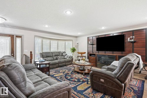 Living area featuring a bay window, recessed lighting, and a built-in media center with a fireplace insert - 12131 101 Street Nw, Edmonton, AB 