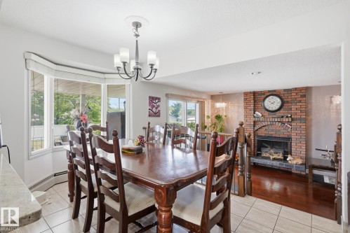 Dining area featuring a bay window, tile flooring, and a chandelier - 12131 101 Street Nw, Edmonton, AB 