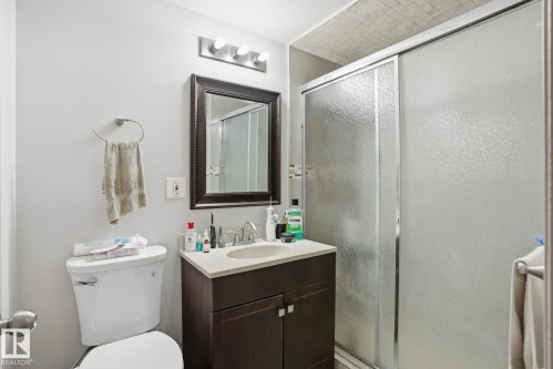 Bathroom featuring a dark wood-finish vanity with a light-colored countertop and undermount sink - 12131 101 Street Nw, Edmonton, AB 