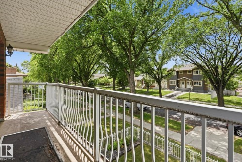 Balcony with decorative white metal railing, overhead soffit, and exterior wall lantern - 12131 101 Street Nw, Edmonton, AB 