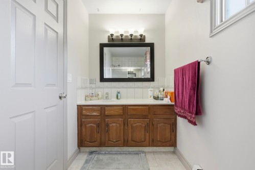 Bathroom with a wood-finish vanity and integrated sink - 12131 101 Street Nw, Edmonton, AB 