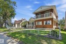 Brick exterior with white accents and a second-story balcony featuring white railings - 12131 101 Street Nw, Edmonton, AB 