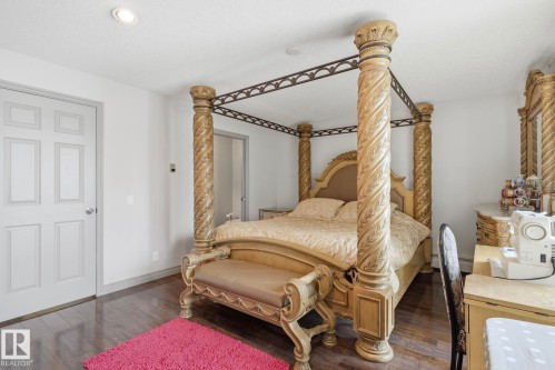 Spacious room featuring wood-finish flooring, recessed ceiling lighting, and a paneled interior door - 12131 101 Street Nw, Edmonton, AB 