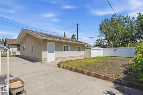 Detached auxiliary building with stucco exterior, multiple windows, and a dedicated entrance - 12131 101 Street Nw, Edmonton, AB 
