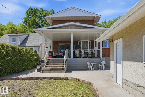 Brick exterior with a covered porch featuring white columns and a decorative railing - 12131 101 Street Nw, Edmonton, AB 
