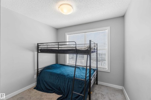 Spacious room featuring neutral paint, soft carpet flooring, a large window with blinds, and a flush mount ceiling light - 1313 Chappelle Boulevard, Edmonton, AB 
