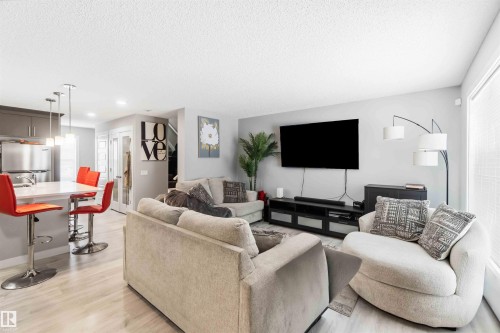 Open-concept living space featuring wood-finish flooring, recessed lighting, and a kitchen island with pendant lighting - 1313 Chappelle Boulevard, Edmonton, AB 