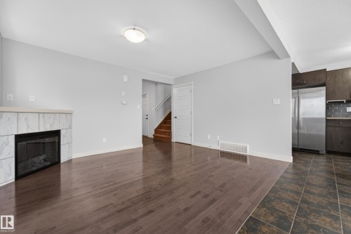 Living area featuring wood-finish flooring and a tiled fireplace - 5244 1A Avenue, Edmonton, AB 