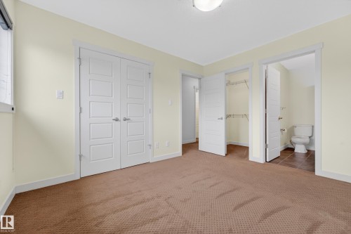 Room featuring brown patterned carpeting, light-colored walls, and a semi-flush mount ceiling light fixture - 5244 1A Avenue, Edmonton, AB 