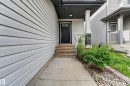 Property exterior with light-colored horizontal siding and a dark front door - 5244 1A Avenue, Edmonton, AB 