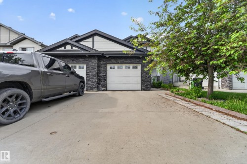 Residence featuring a stone and siding exterior with a dark roofline - 5244 1A Avenue, Edmonton, AB 