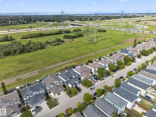 Aerial view showcasing a residential street with detached homes, green spaces, and highway infrastructure - 5244 1A Avenue, Edmonton, AB 