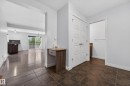 Entryway featuring brown-toned tile flooring, light gray wall paint, and white trim - 5244 1A Avenue, Edmonton, AB 