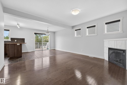 Living space featuring wood-finish flooring and a tiled fireplace - 5244 1A Avenue, Edmonton, AB 