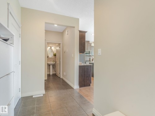 Entryway featuring contemporary tile flooring, light neutral wall paint, and white trim - 3 1641 James Mowatt Trail, Edmonton, AB 
