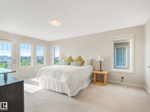 Carpeted room featuring multiple windows offering abundant natural light - 3 1641 James Mowatt Trail, Edmonton, AB 