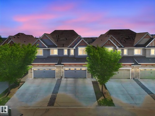Modern townhomes featuring multi-tone siding, stone accents, and pitched roofs - 3 1641 James Mowatt Trail, Edmonton, AB 