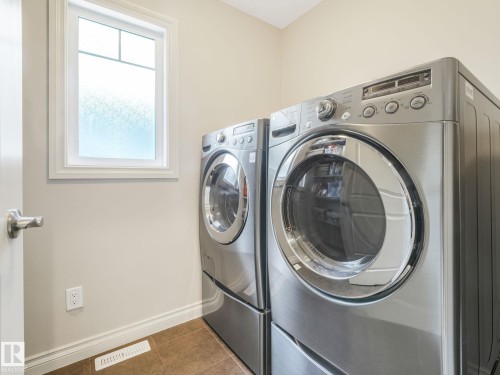 Laundry area featuring a front-loading washer and dryer set - 3 1641 James Mowatt Trail, Edmonton, AB 