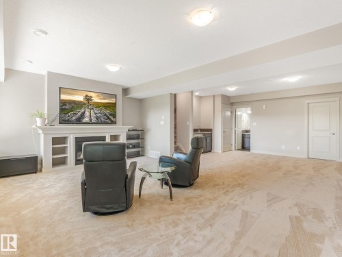 Spacious recreation room featuring light-toned carpeting and recessed lighting - 3 1641 James Mowatt Trail, Edmonton, AB 